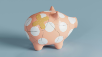 A picture of a dotted piggy bank that's been glued back together and has a plaster on it