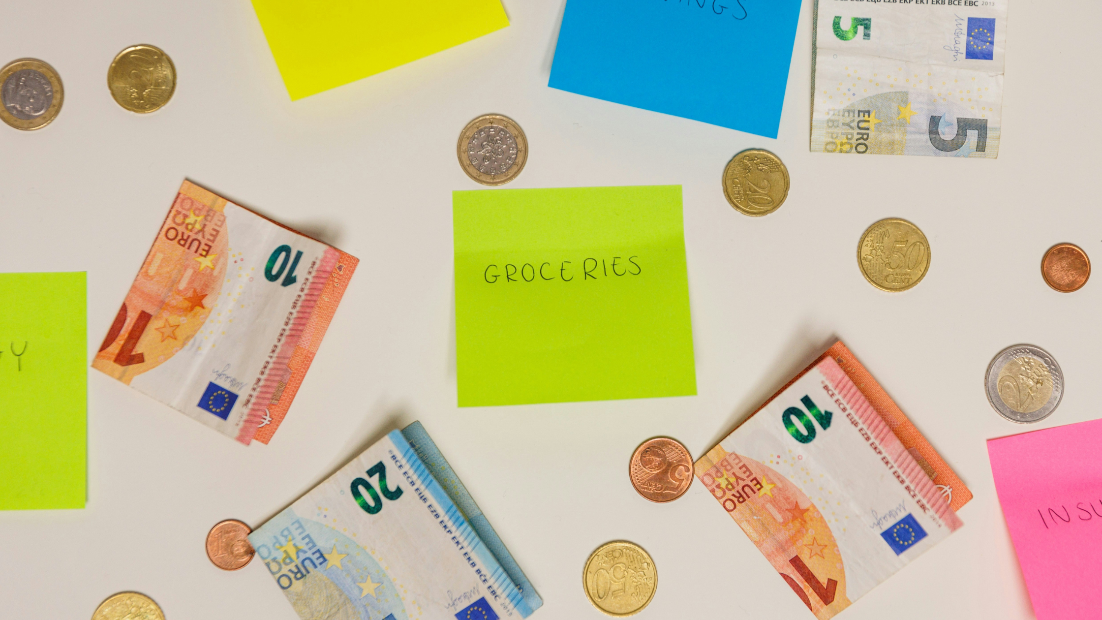 Money notes, coins and post it notes sit on a table