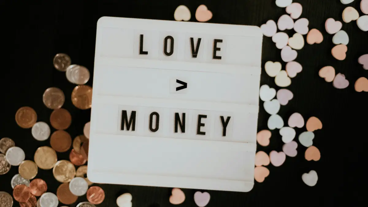 A sign shows the message 'Love > Money'