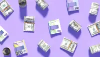 Piles of different currency money notes sit against a stylised purple background