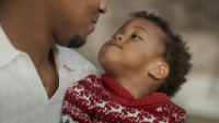 A young man looking into his son's face