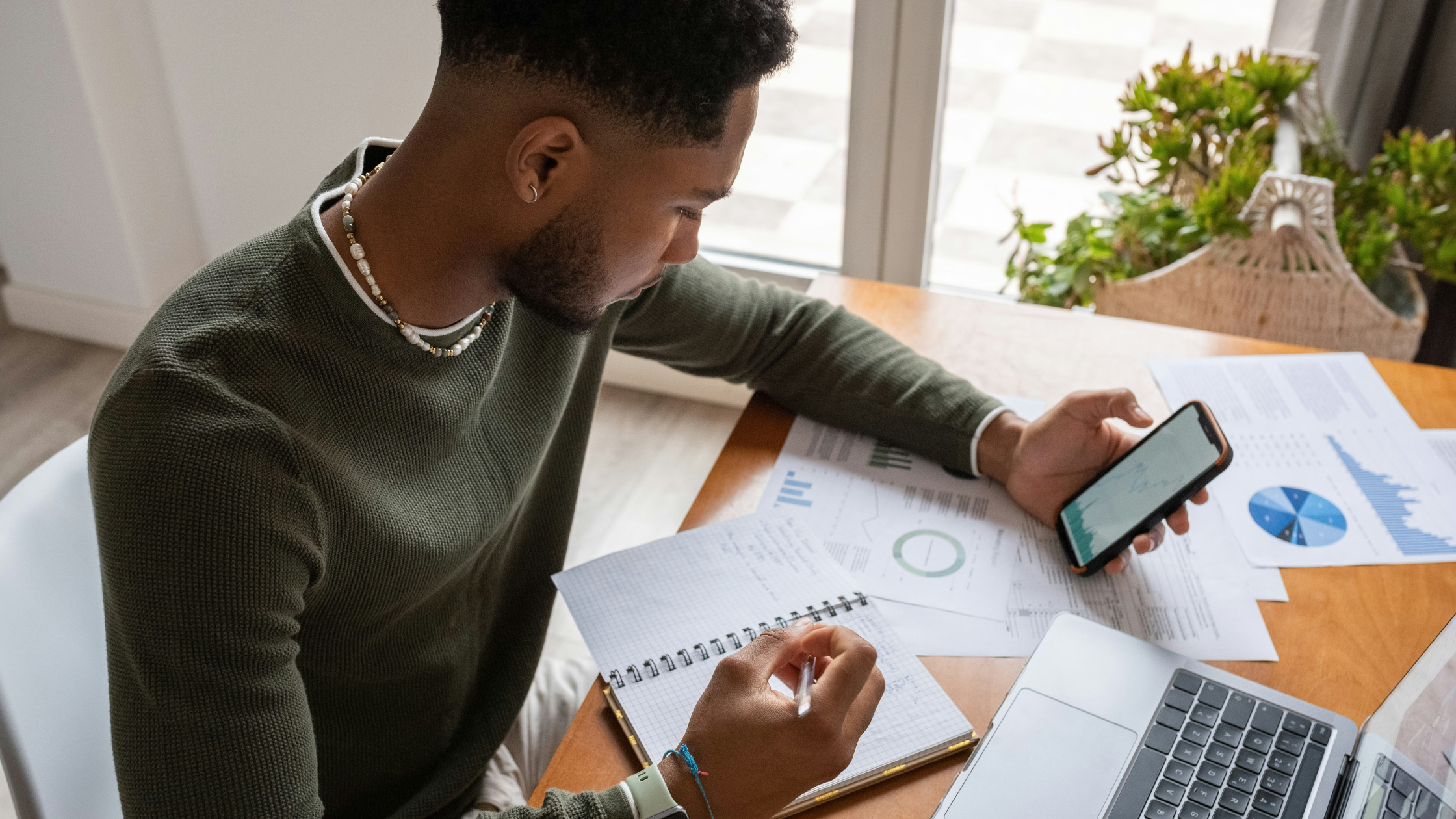 A young man calculating his finances at a desk