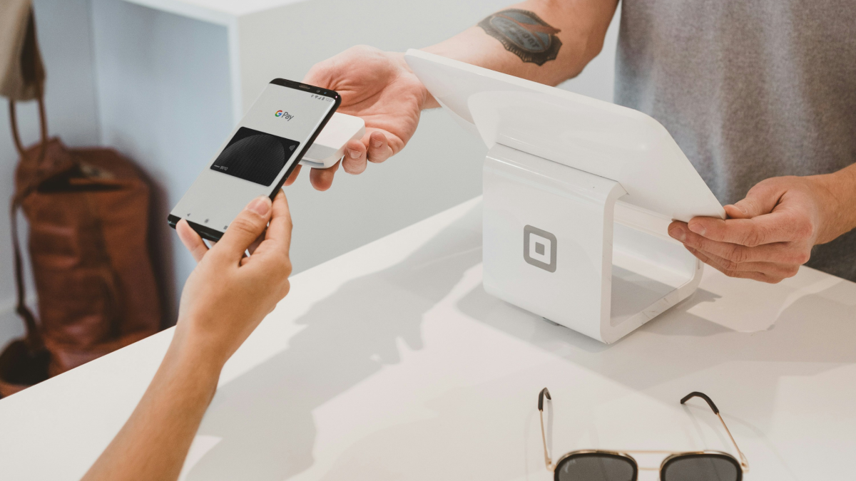 someone making a payment through google pay on their iphone