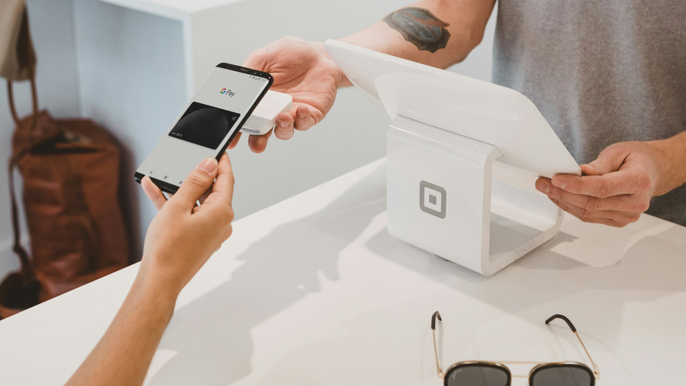 someone making a payment through google pay on their iphone