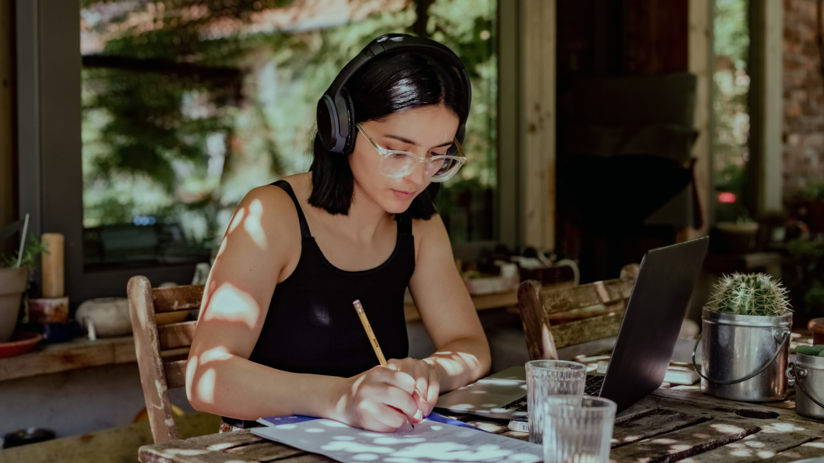 a young woman works outside at a table