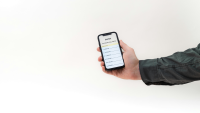 a man holds a phone that shows his banking app