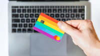 a hand holding a colourful, striped bank card
