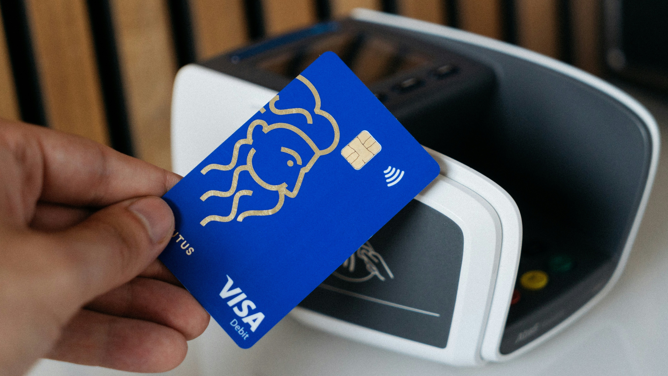 a picture of someone paying with a visa contactless bank card