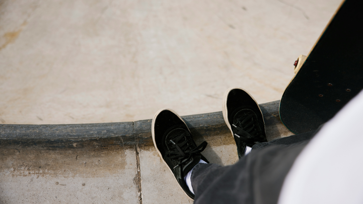 an image of a man's feet on the edge of a skate ramp