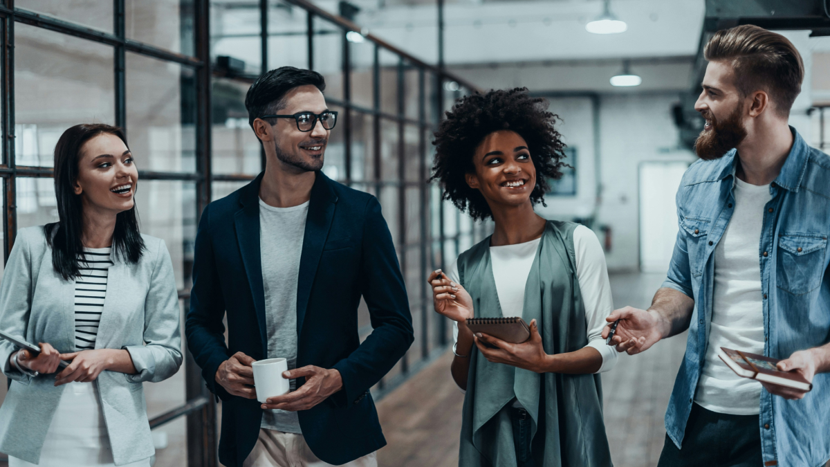 four stylish people chat in an office setting