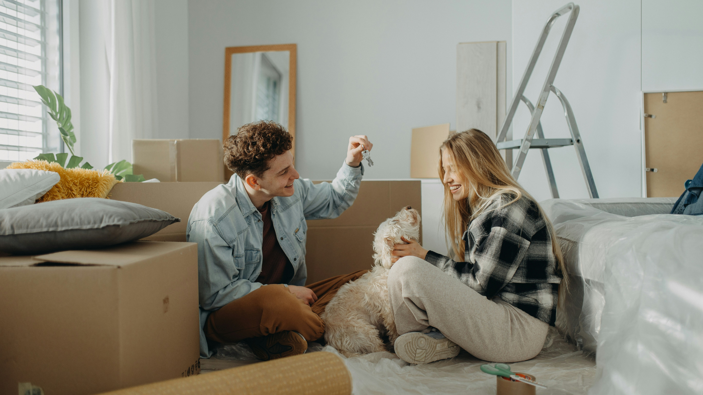 a young couple who have just moved in pet their dog