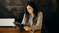 a young woman works on her tablet