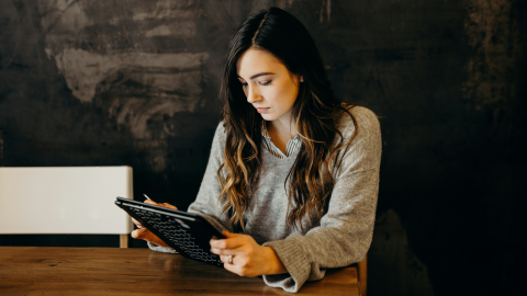 a young woman works on her tablet