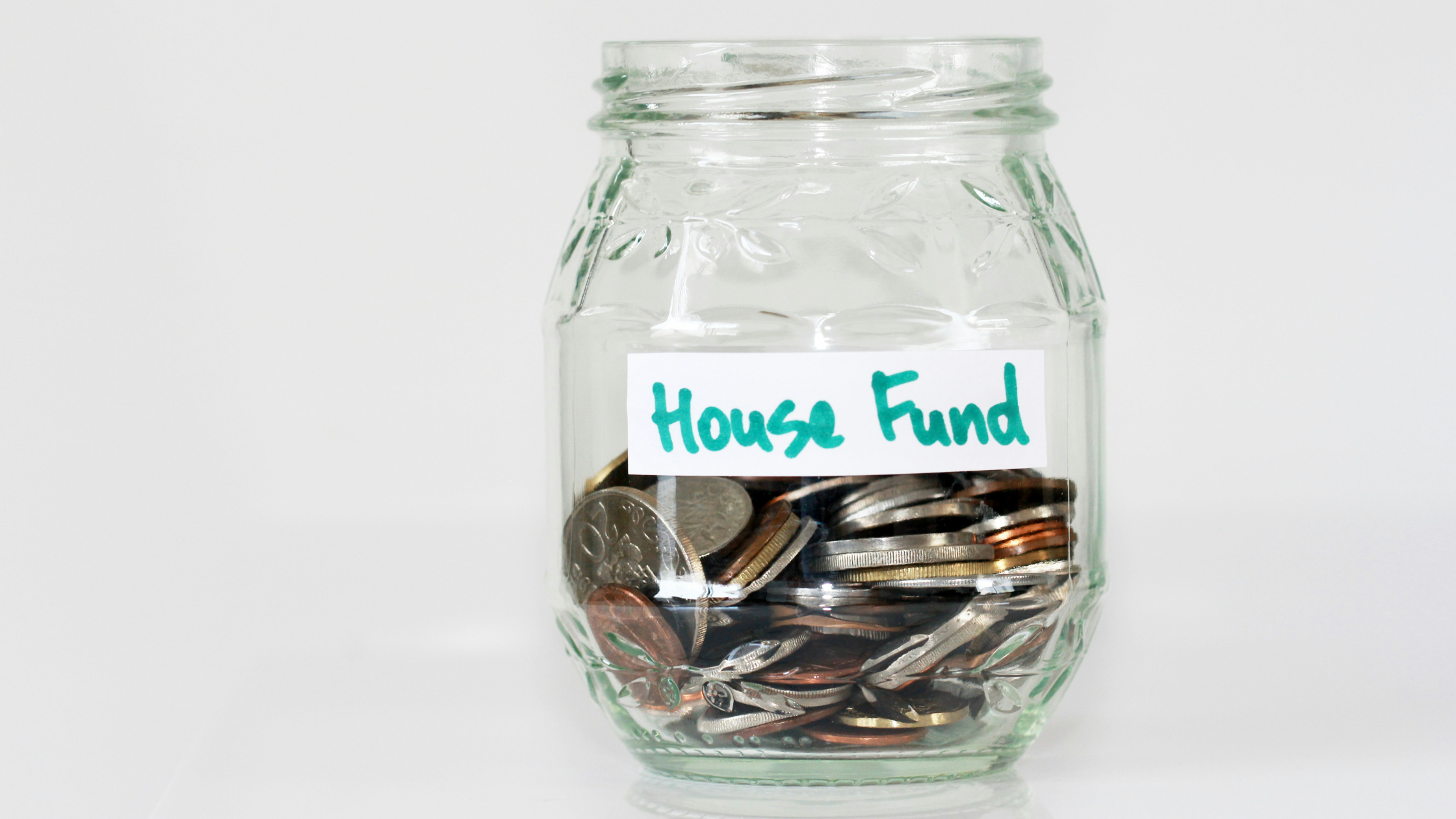 a glass jar labelled 'house fund'