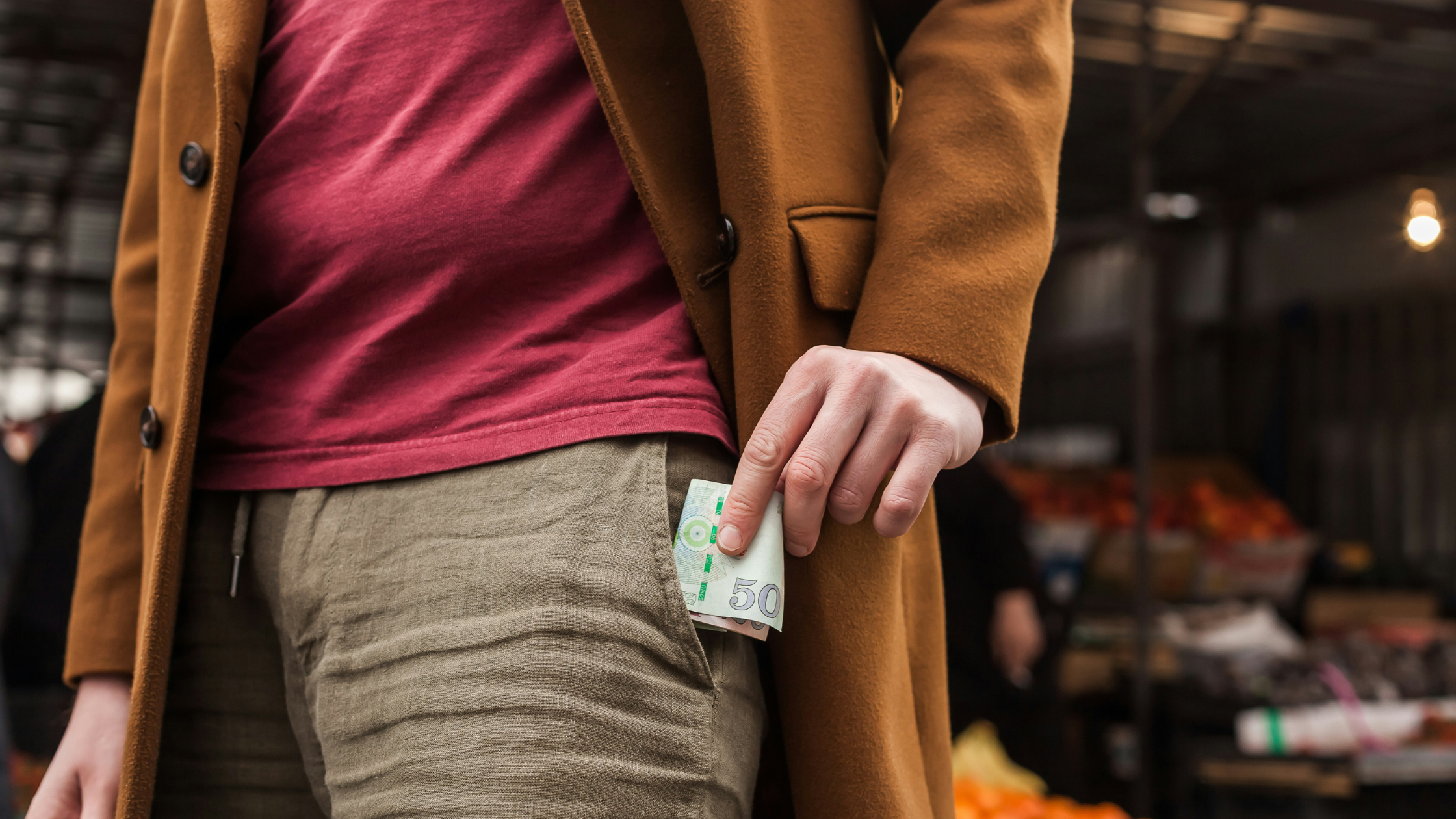 a man pulls a bank note out of his pocket