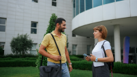 two students talk outside their university