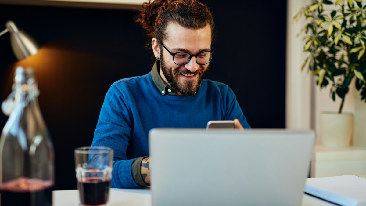 a man smiles at his phone at work
