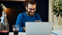 a man smiles at his phone at work
