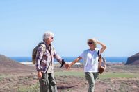 An older couple hold hands