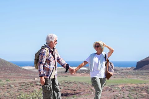 An older couple hold hands