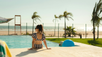 a woman sits at the edge of a pool