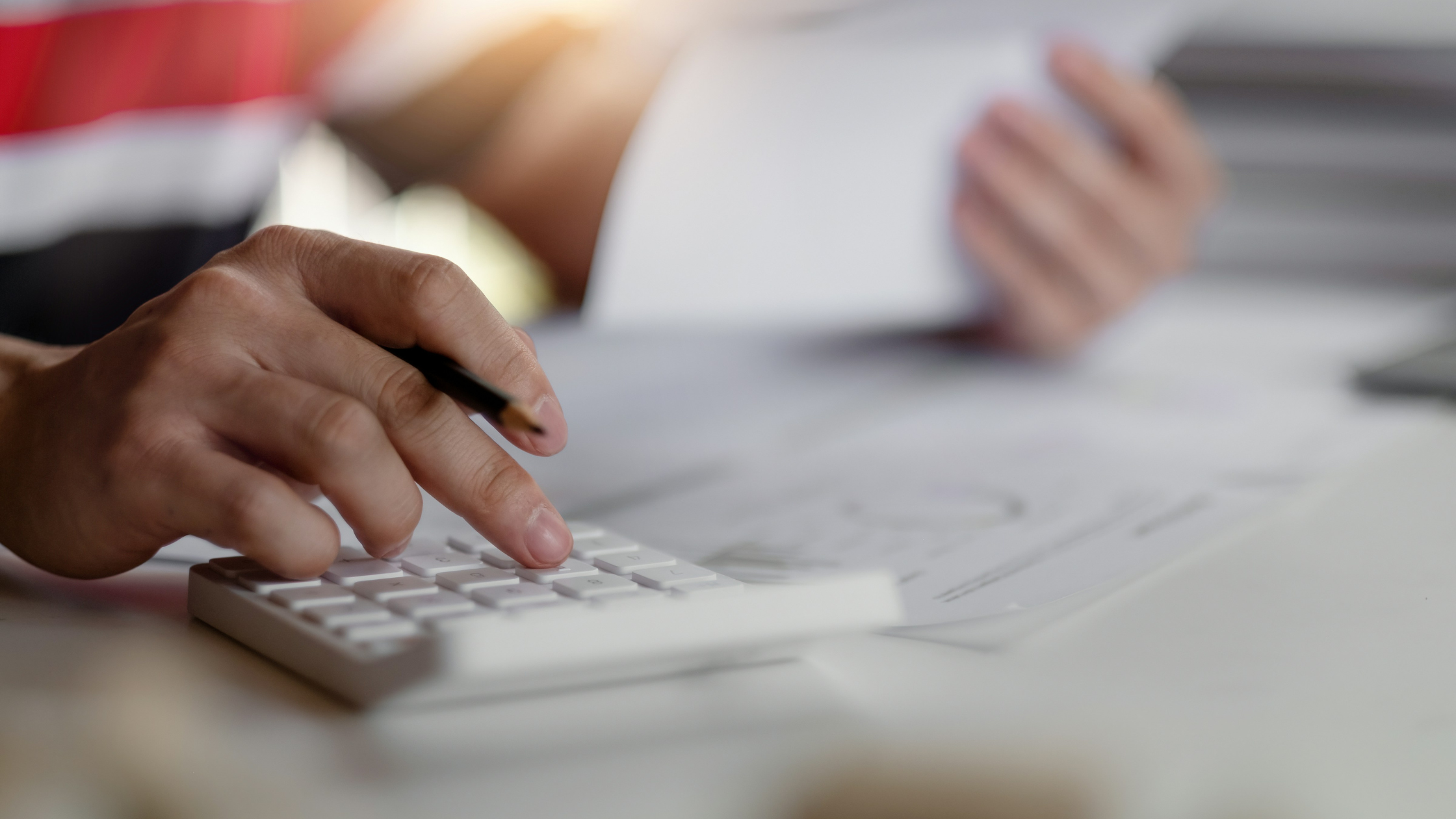 someone's hand, typing on a calculator