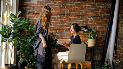 two women talk in a stylish office