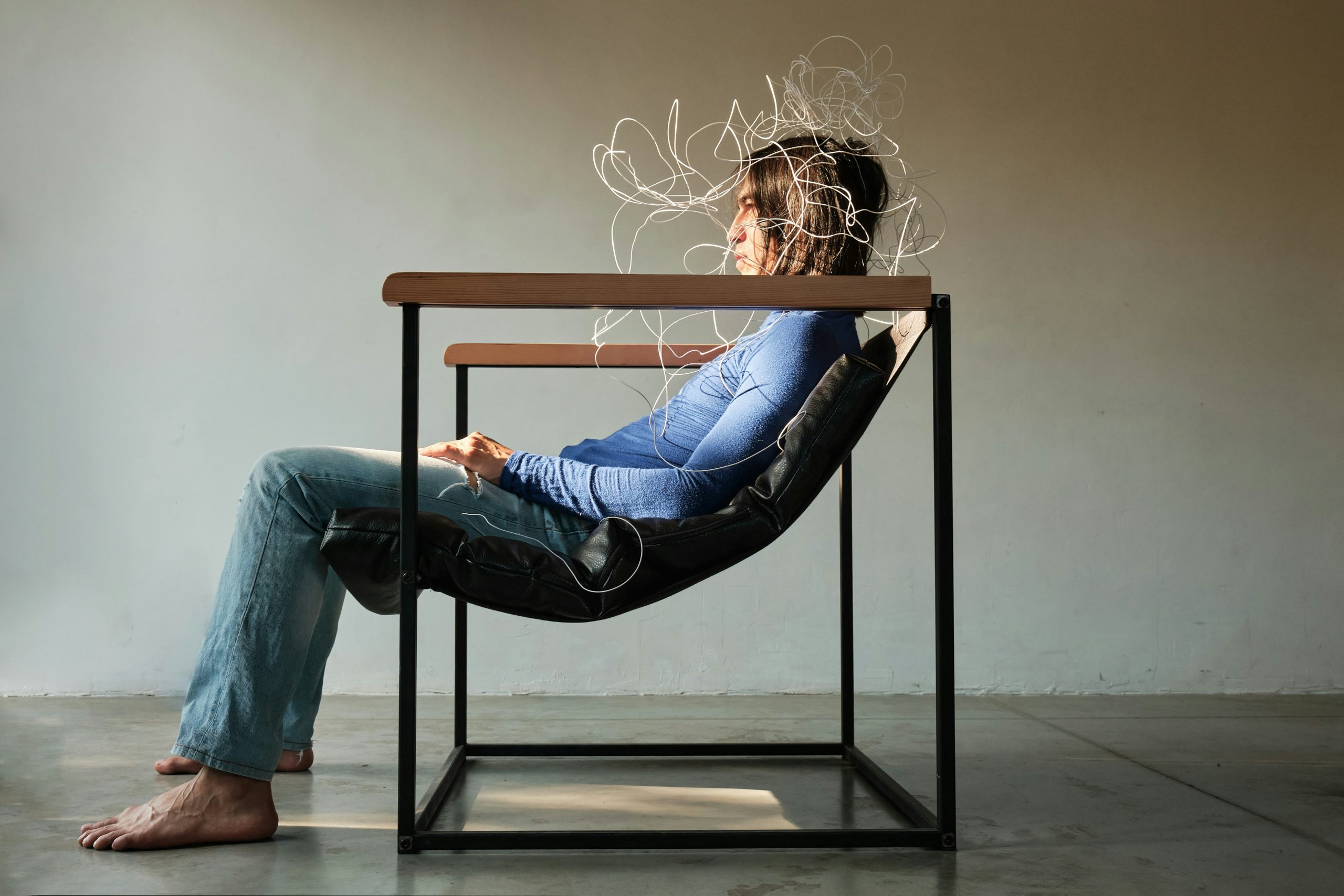 A woman sits in a chair, looking overwhelmed