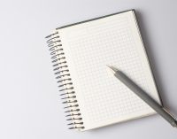 A blank notebook with a pen