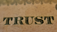 the word 'trust' on a banknote