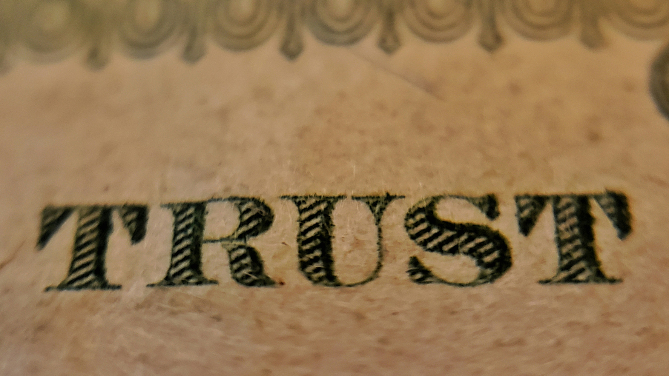 the word 'trust' on a banknote