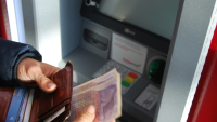someone counting money at an atm