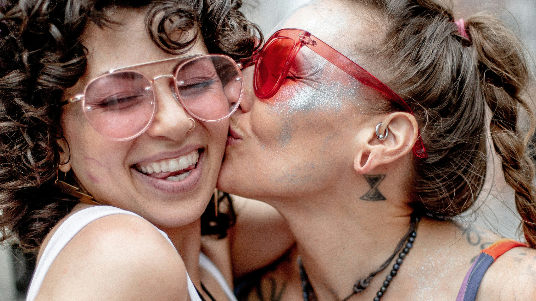 a woman kissing another woman's cheek