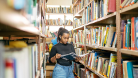 a girl in a library holding a book
